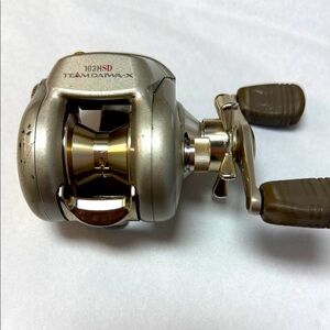 Team Daiwa-X 103HSD right handed Silver and Gold Fishing Reel